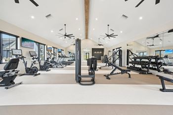 A gym with a variety of equipment including treadmills, stationary bikes, and weight machines.